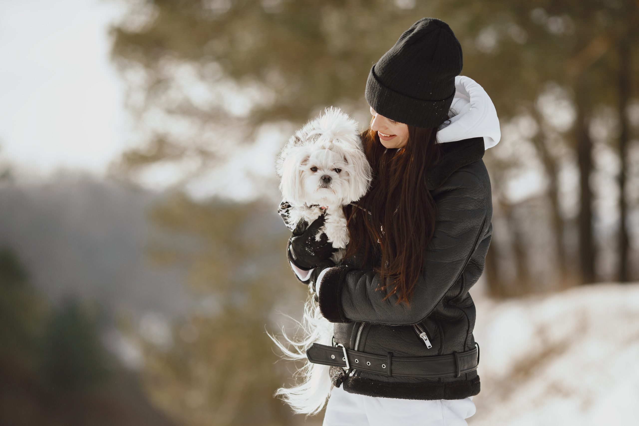 young woman hugging her dog close up outdoors